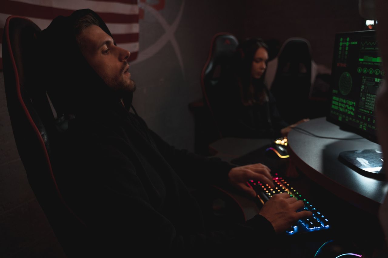 Mastering the First Impression: Your intriguing post title goes here Young adults working on cybersecurity tasks in a dimly lit tech environment.